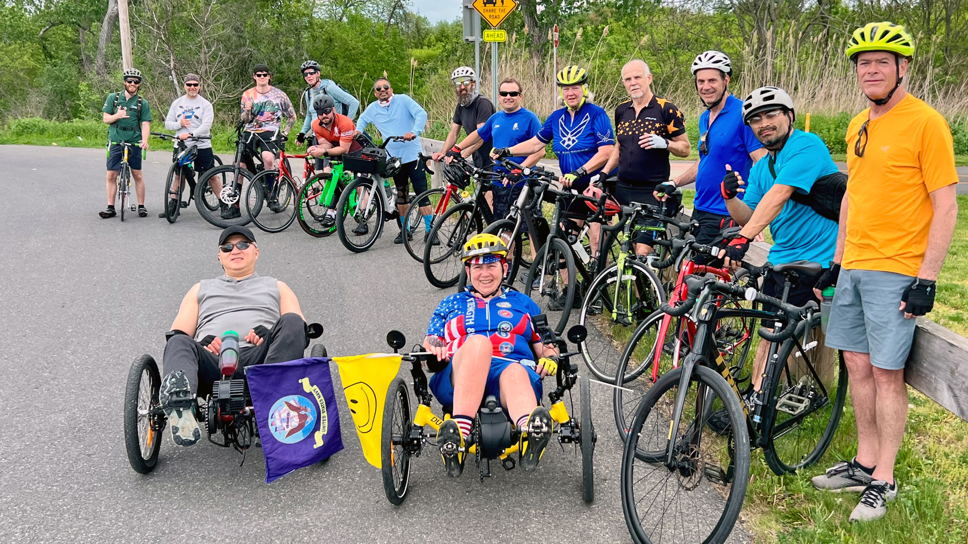 Group of cyclists smiling wit their bikes