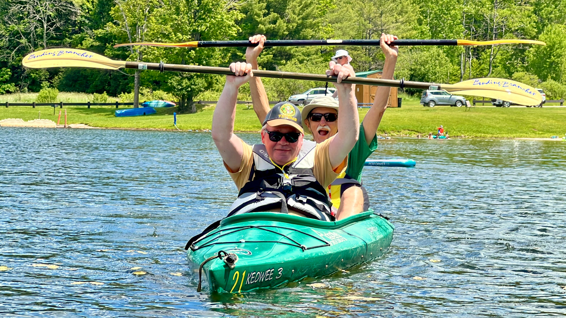 Two people raising their paddles in a kayak
